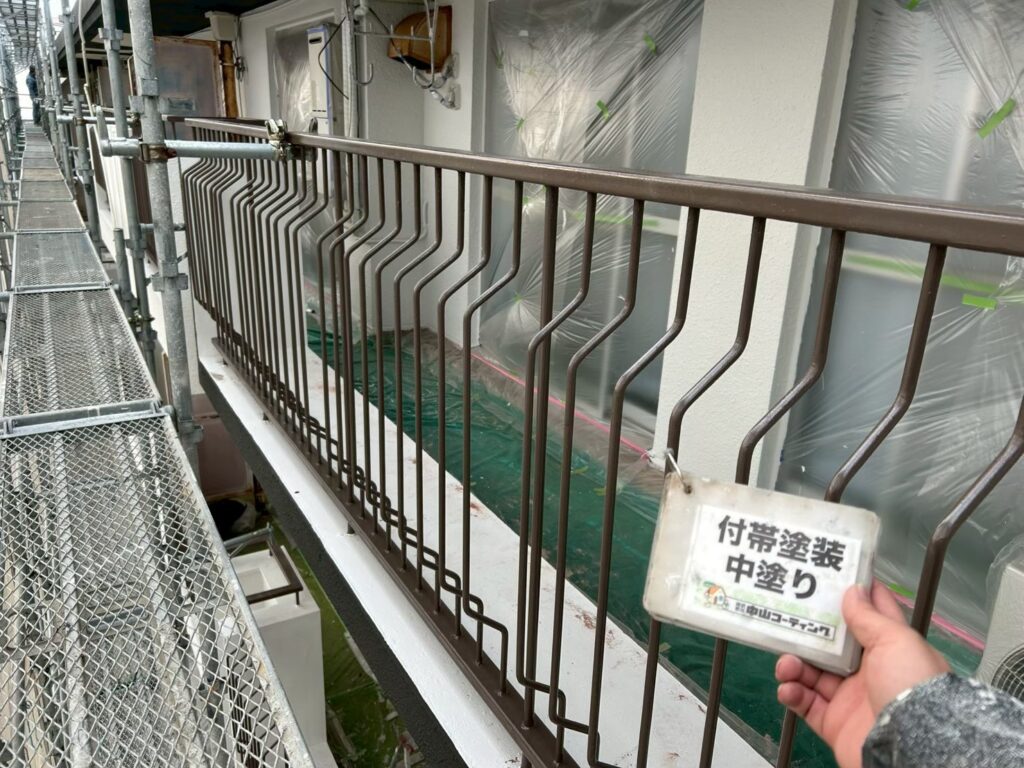 手すりの中塗りを行い、塗膜の厚みを確保しています