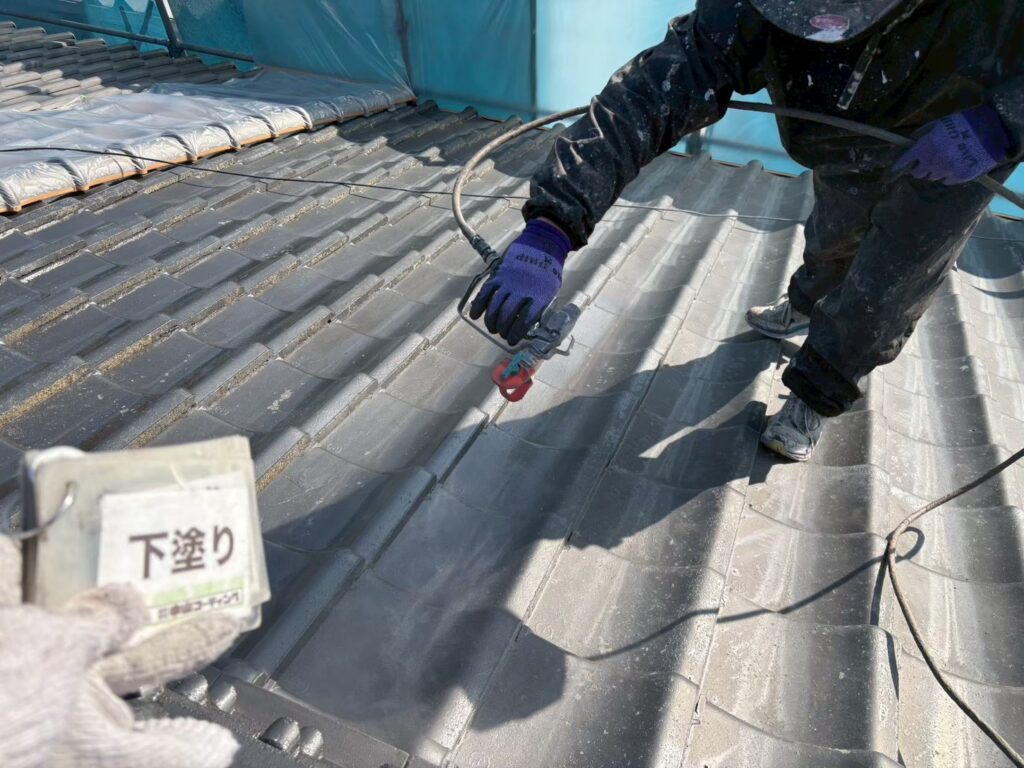 屋根瓦に下塗り材を吹き付けています