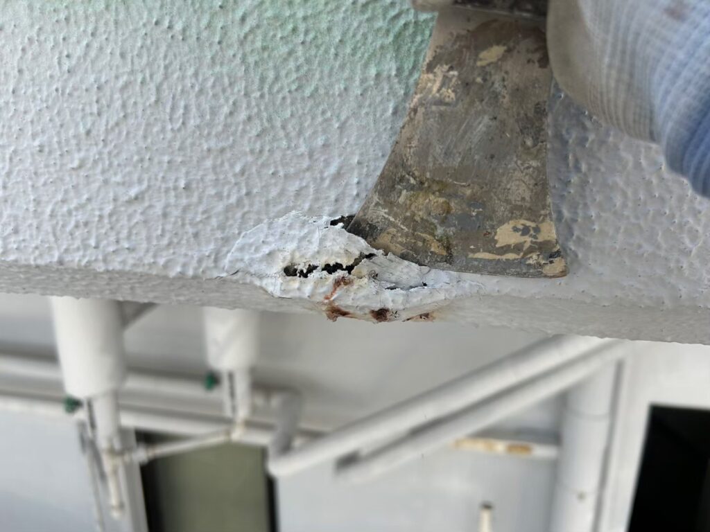 膨れの部分をスクレーパーで除去しています