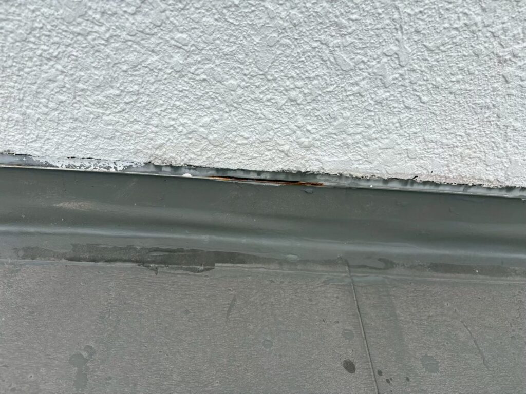 外壁と水切りの取り合い部分に隙間が見られ、部分的に錆が確認できます