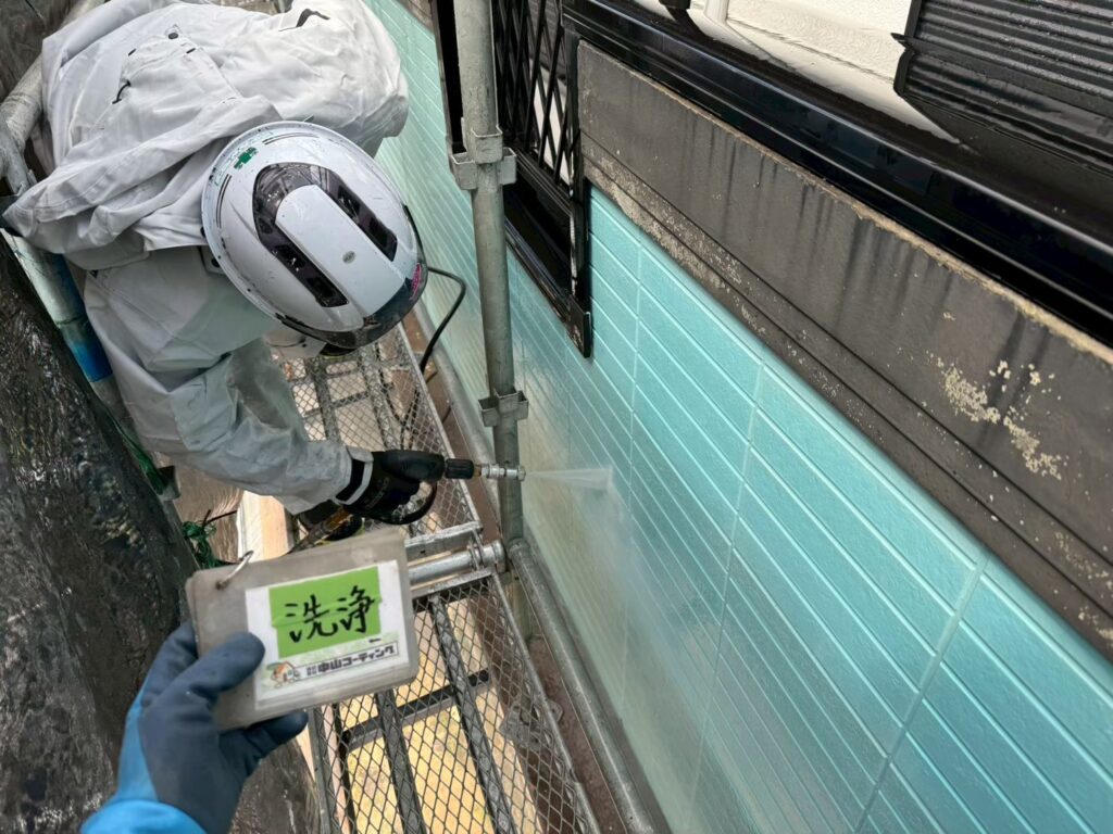 外壁を高圧洗浄し、長年付着した汚れや古い塗膜を丁寧に除去しています