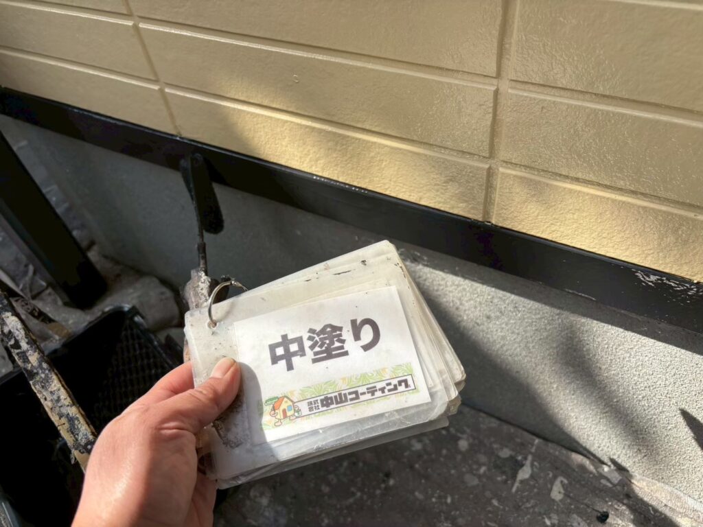 外壁と基礎の取り合い部分にある水切り板金の中塗りを行っています