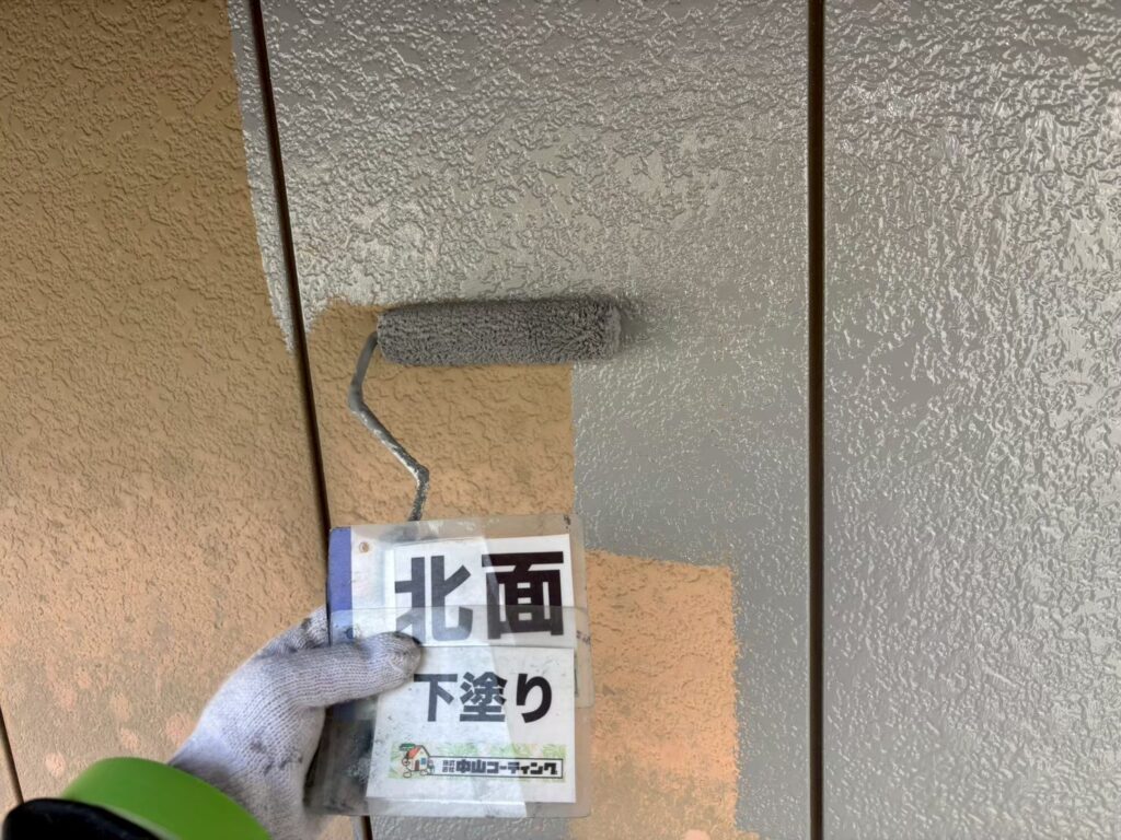 北面の外壁に下塗りを行い、塗料の密着性を高めていきます