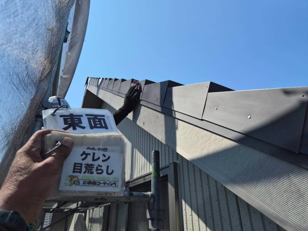 屋根の端にある板金をヤスリでこすり、塗料が密着しやすいよう表面を整えます
