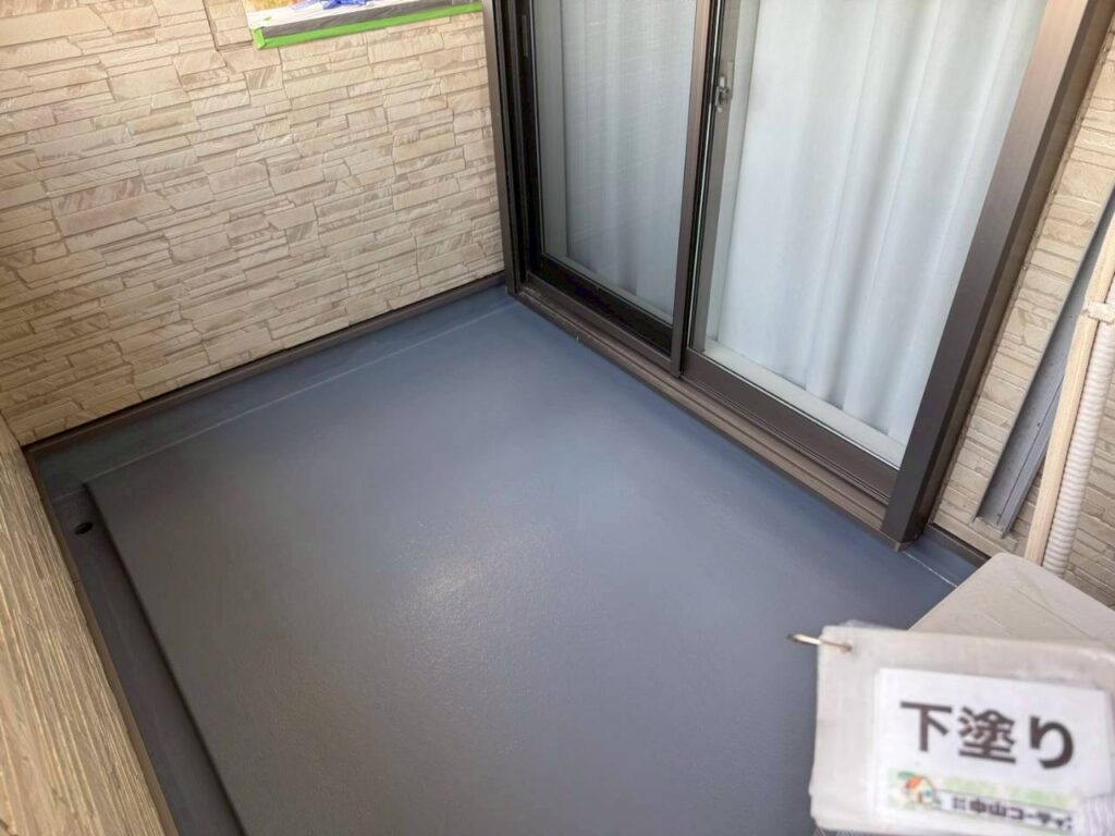 下地調整と清掃を終えたベランダ床に下塗りを施工しました