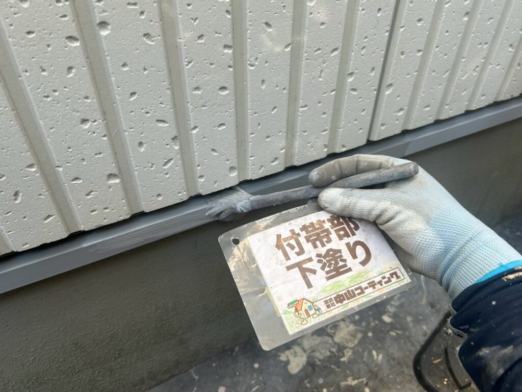 土台水切りを刷毛で下塗りしています