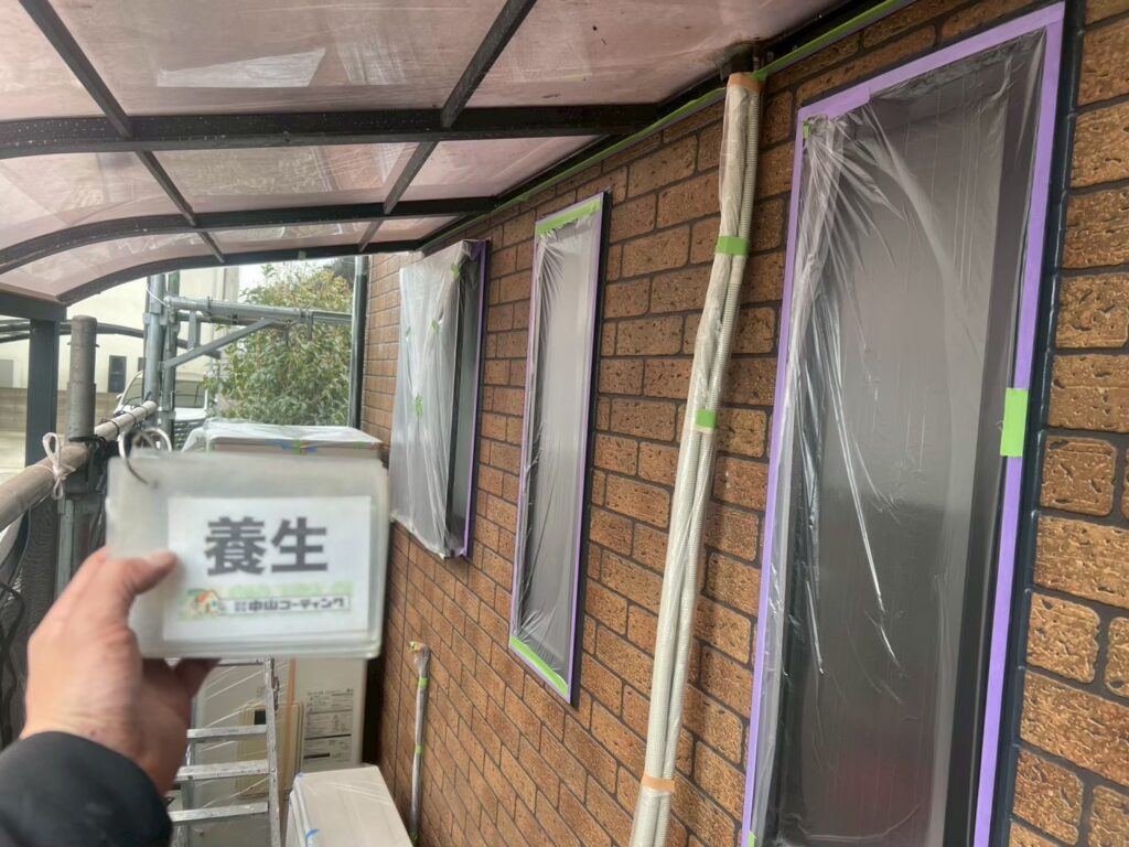 塗装作業に入る前に、窓や配管などの周辺設備を丁寧に養生しています
