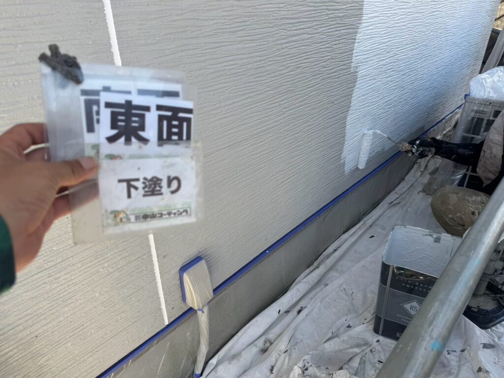 塗料の密着を助ける下塗り材を、丁寧に塗っています