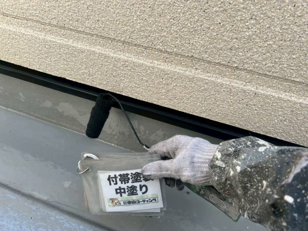 外壁と板金部分の取り合いに沿って、中塗りを進めている様子です