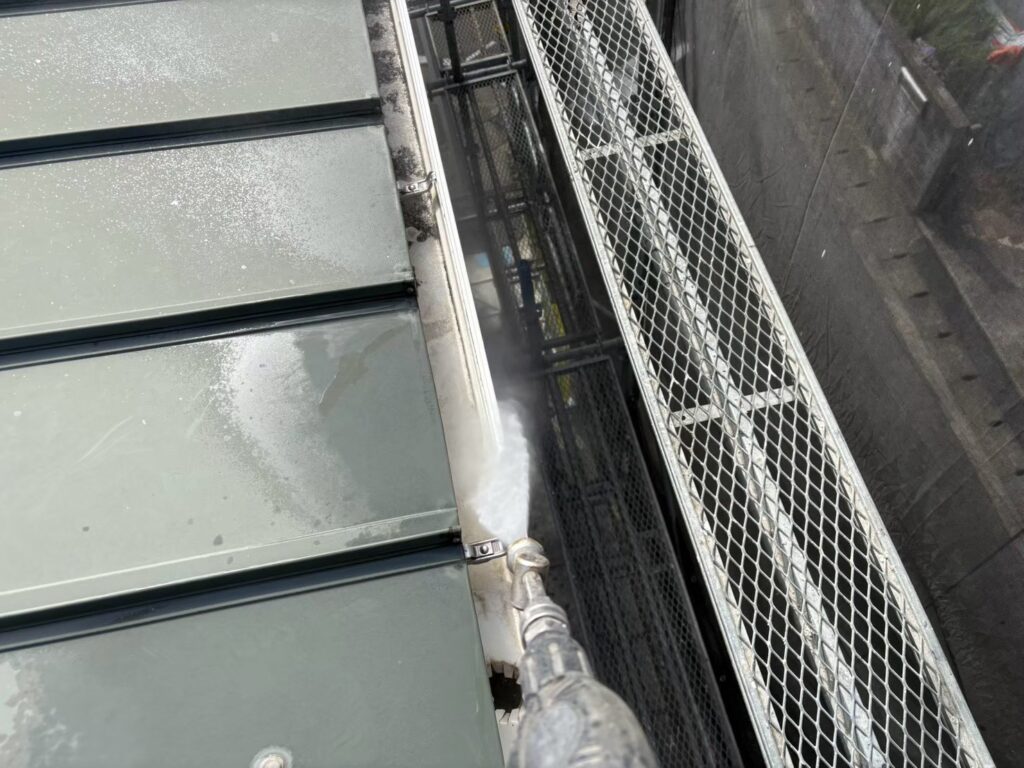 雨樋の内側にたまった汚れを、高圧洗浄で洗い流しています