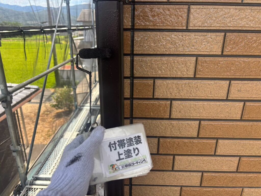 縦樋の上塗りが完了し、外壁になじむブラウンに仕上がりました