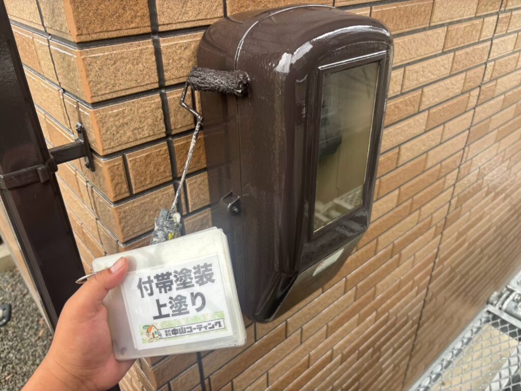 電気ボックスに上塗りを行い、ブラウンの塗料を丁寧に塗り重ねます