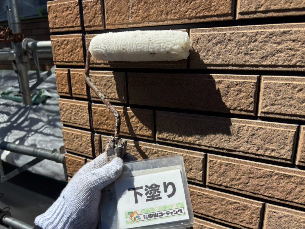 外壁全体に下塗り材を塗布し、上塗り塗料が密着しやすい状態に整えます
