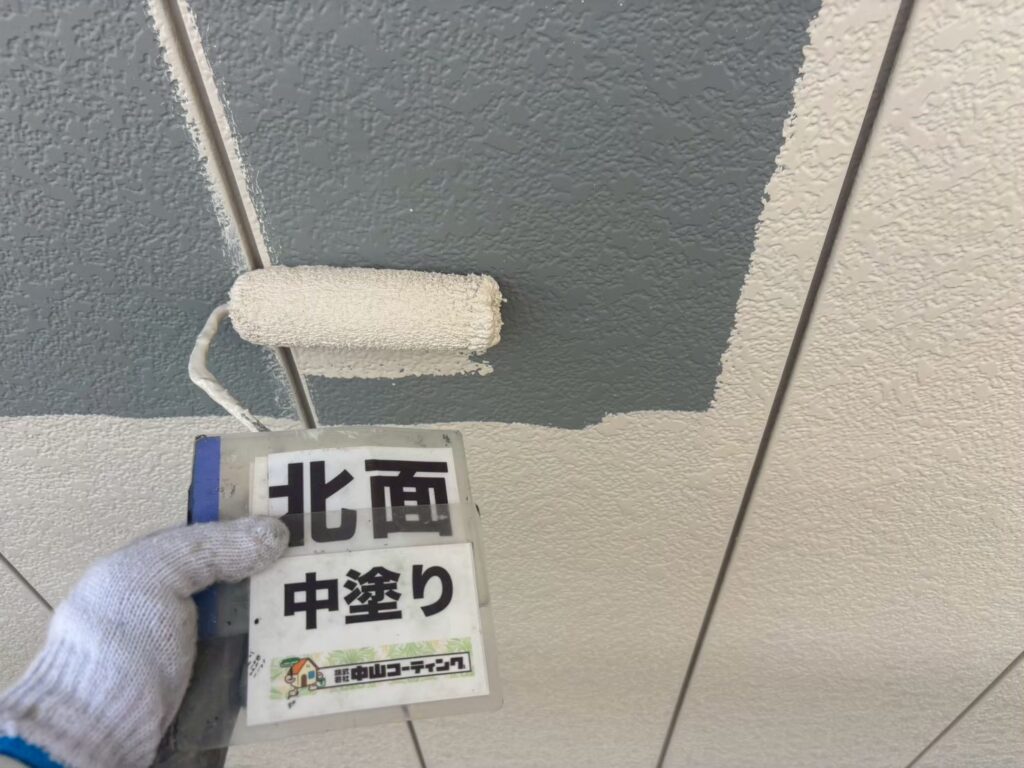 北面の外壁に中塗りを行い、塗膜に厚みを持たせていきます