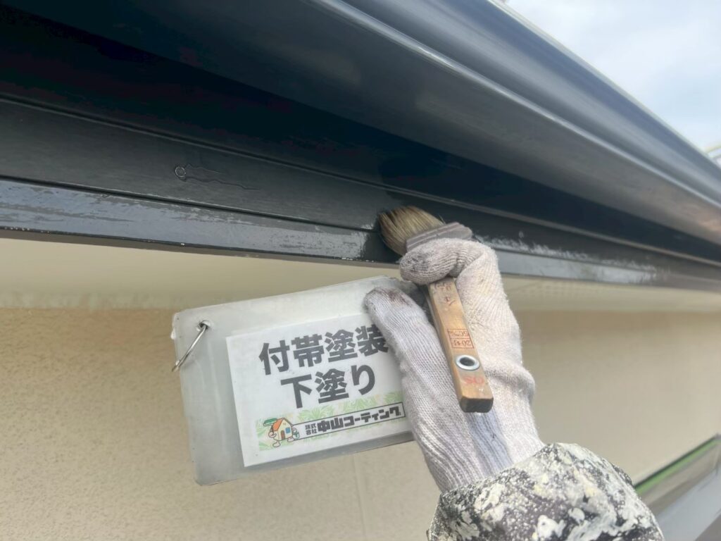 雨樋付近の付帯部分に、刷毛を使って下塗りを施しています
