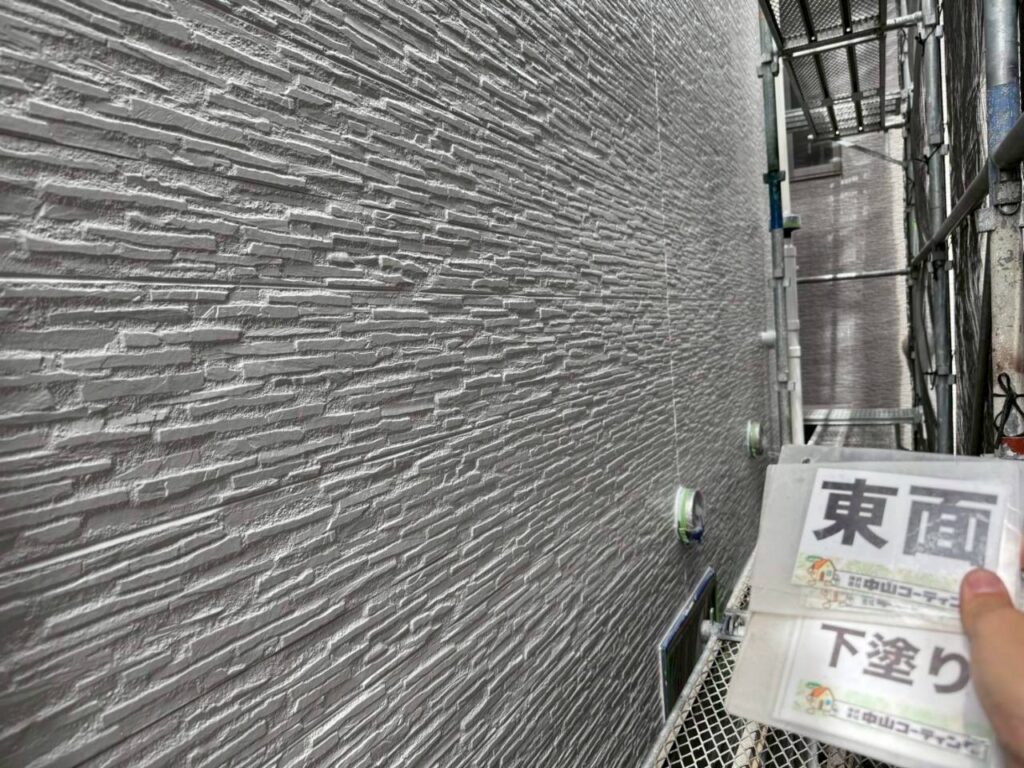 白い外壁の細かな溝まで、下塗り材をしっかりなじませました