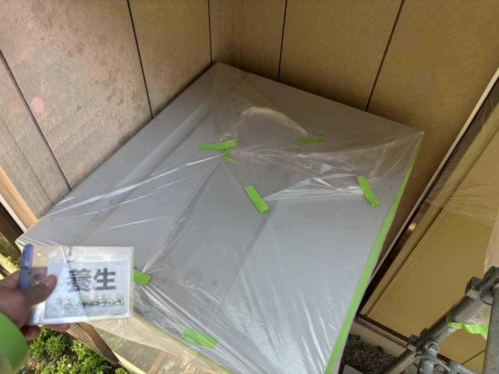 庇全体をビニールでしっかり覆い、塗料の付着を防ぐ養生を行いました